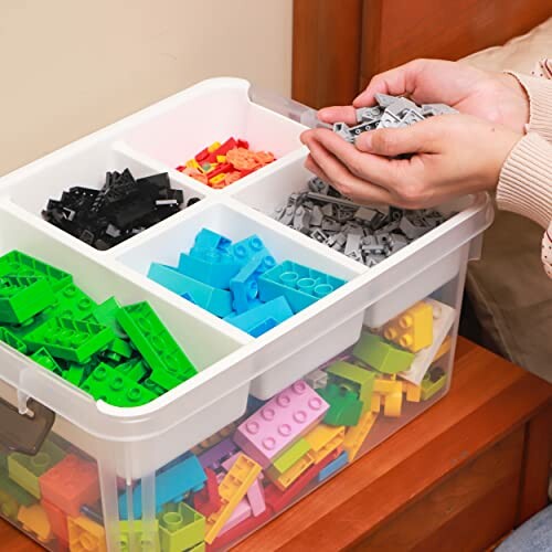 Person sorting colorful Lego bricks in a plastic storage box.