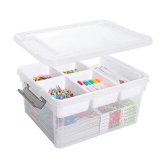 Transparent plastic storage box with lid, containing dividers and various items like markers and clips.